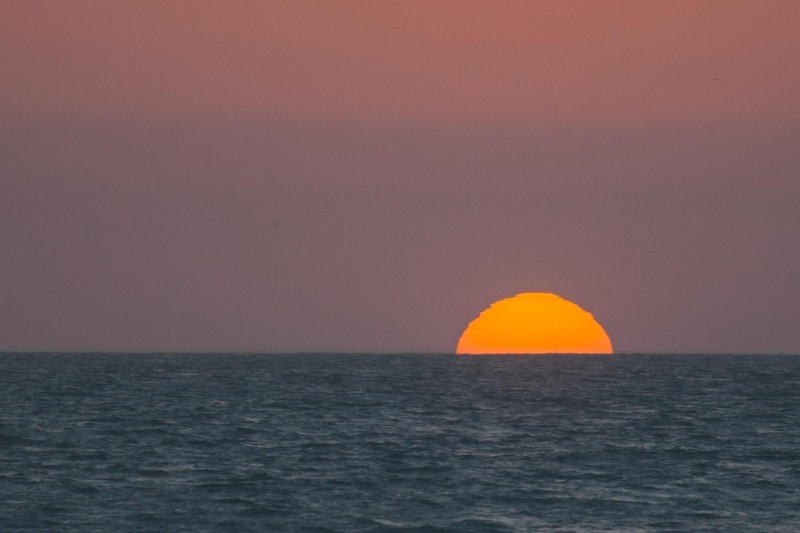 A photo of the sun at the horizon.