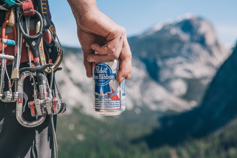 A photo of a Pabst Blue Ribbon beer PBR with mountains in the background